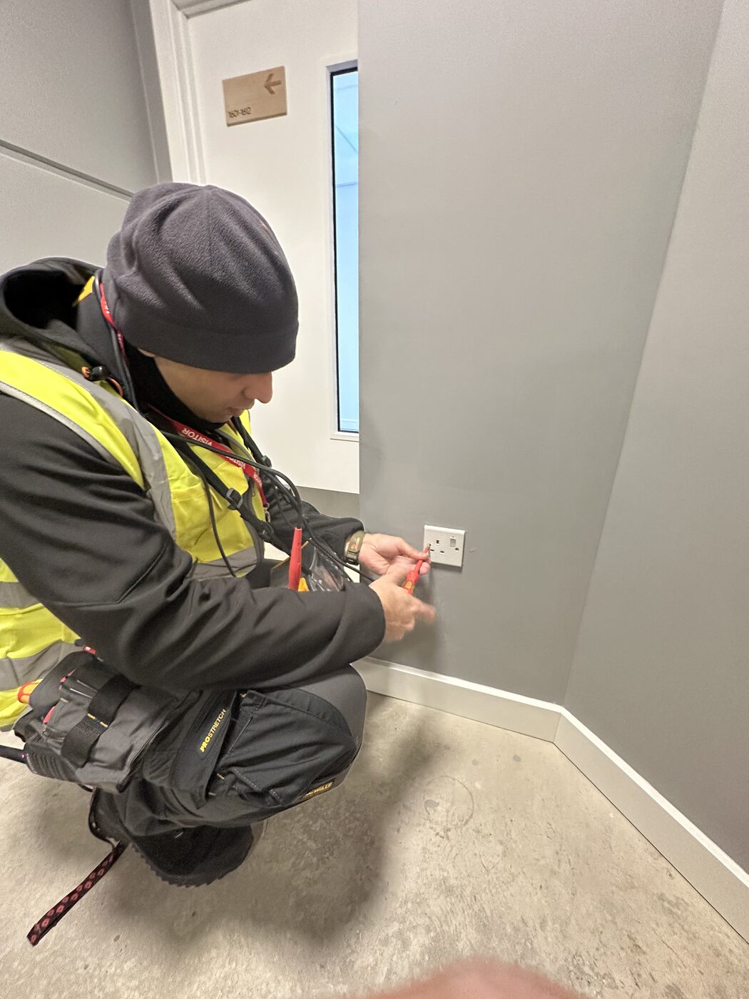 Electro Sure electrician inspecting a commercial distribution board during an EICR in Greater Manchester